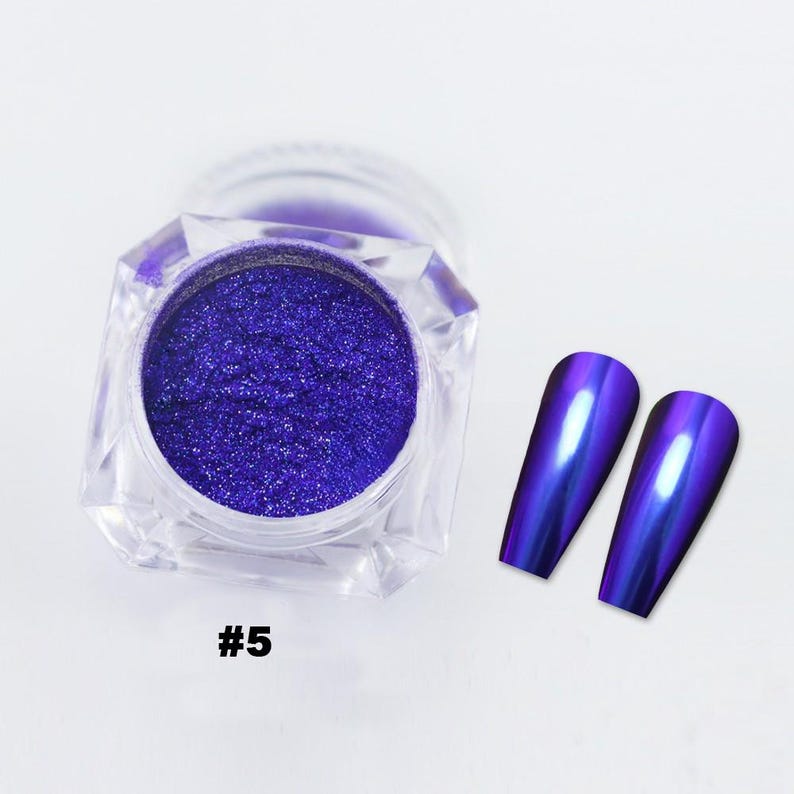 May include: A clear, faceted jar filled with vibrant, sparkling purple nail powder. Two long, oval-shaped nail tips with a metallic, iridescent purple finish are displayed next to the jar. The number "#5" is printed in white.