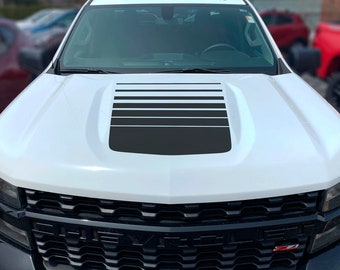 May include: A white pickup truck with a black hood stripe decal. The decal has a series of horizontal black stripes.