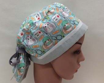Può includere: Un cappello da lavoro blu e bianco con un motivo di porcellini d'India, bende e kit di pronto soccorso. Il cappello ha un bordo bianco con piccoli pois blu.