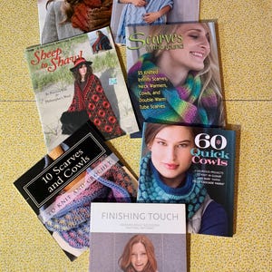 May include: A collection of seven instructional knitting books featuring patterns for cowls, shawls, and scarves. The covers display various knitted accessories, including colorful infinity scarves, textured wraps, and fingerless gloves with descriptive titles.