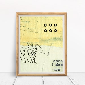 May include: A framed abstract art print with a yellow background and black text. The text includes the letters "OOO" and "OXO".