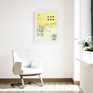 May include: A white chair with a black metal frame sits in a room with white walls and a framed abstract art print. The print features yellow and green colors with black text and circles. A window with white blinds is in the background.