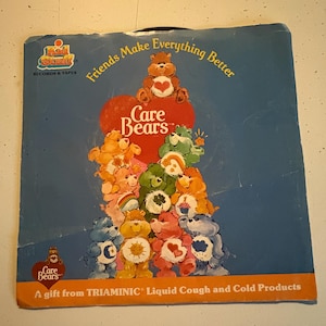 May include: Vintage Care Bears record album cover. The cover features a blue background with a heart-shaped design and several Care Bears characters. Text includes "Friends Make Everything Better" and "A gift from TRIAMINIC Liquid Cough and Cold Products."