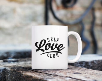 May include: White ceramic mug with black text that reads "Self Love Club".