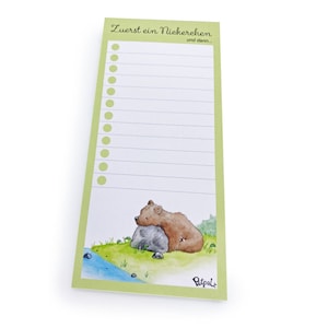 Könnte beinhalten: Rechteckiger Notizblock mit hellgrünem Rand und einer skurrilen Illustration eines Bären, der sich auf einem Felsen ausruht. Der Notizblock hat linierte Seiten und eine Überschrift mit der Aufschrift "Zuerst ein Nickerchen und dann..."