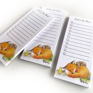 Könnte beinhalten: Drei rechteckige Notizblöcke mit einer Fuchsgrafik. Der Fuchs ist orange und weiß, zusammengerollt auf grünem Gras mit einem kleinen braunen Tier und einem gelben Küken. Jeder Notizblock hat oben den Text "Let's do this!"