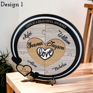 May include: A wooden heart-shaped puzzle with the words "Love is a beautiful journey" and the names "Kylei, Shauna, Jayson, William, Alivia, Nicholas" and the date "6.27.2020".