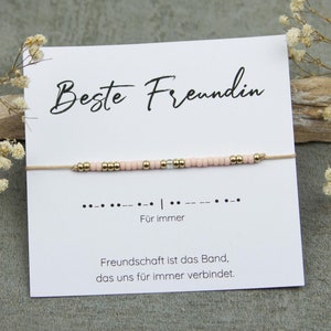 Könnte beinhalten: Ein rosafarbenes und goldenes Perlenarmband mit einer Karte, auf der "Beste Freundin" und "Für immer" steht. Die Karte sagt auch "Freundschaft ist das Band, das uns für immer verbindet".