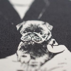 May include: A monochrome graphic featuring a pug dog. The image is a close-up, highlighting the dog's face and expression. The pug is rendered with detailed shading and a textured effect. The background is a dark, textured surface.