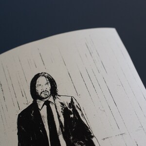 May include: Monochrome illustration of a man in a suit, with long hair and a beard, set against a white backdrop with vertical lines. The image is a close-up, showing the man's face and upper body.