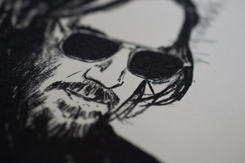 May include: Close-up black and white sketch of a person's face wearing sunglasses. The sketch is detailed, with visible lines and shading, creating a textured appearance. The image is on a white background.