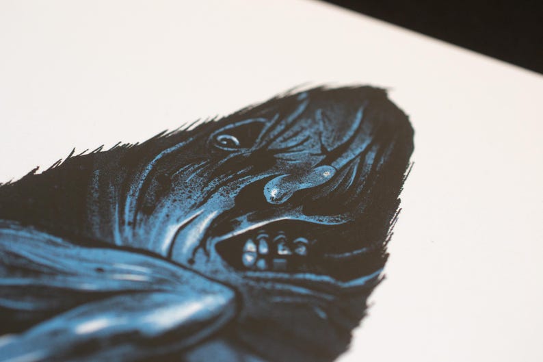 Puede incluir: Una impresi&oacute;n art&iacute;stica de alto contraste sobre papel blanco que presenta una ilustraci&oacute;n en azul oscuro y negro de una criatura con un rostro texturizado y expresivo. La figura muestra l&iacute;neas n&iacute;tidas y dentadas, una boca abierta con dientes.