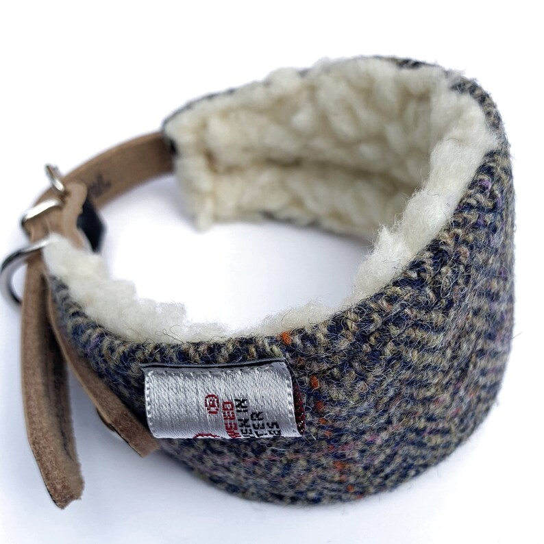 May include: A brown leather dog collar with a tweed and fleece lining. The collar has a silver buckle and a label that reads "Made in England, Leather, Size 13".