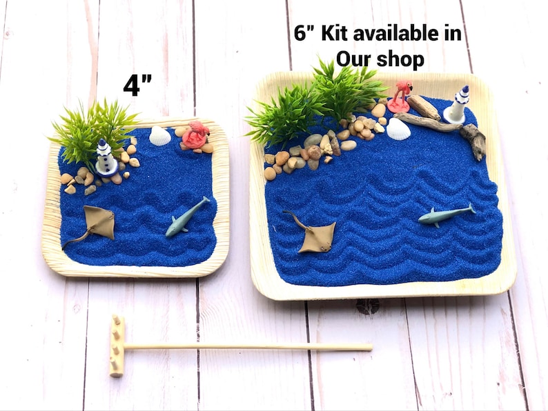May include: Two blue sand tray kits with a beach theme. The smaller tray is 4 inches and the larger tray is 6 inches. Both trays have blue sand, a lighthouse, a seashell, a starfish, and a palm tree. The text "6" Kit available in Our shop" is printed on the image.