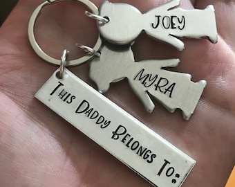 May include: Silver keychain with a tag that reads "This Daddy Belongs To:" and two small silver figures with the names "Joey" and "Myra" engraved on them.
