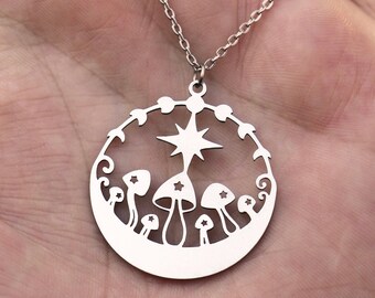 May include: A silver necklace with a circular pendant featuring a star and mushrooms. The pendant is cut out, creating a delicate design.