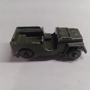 May include: A green toy jeep with a black interior and a star on the hood.