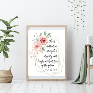 May include: A printable wall art design featuring a watercolour floral illustration with pink roses and gold geometric shapes. The text reads "She is clothed in strength & dignity and laughs without fear of the future. - Proverbs 31:25"