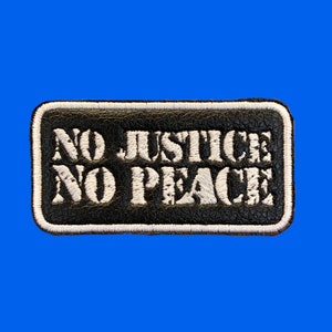 May include: Black leather patch with white stitching and the text "NO JUSTICE NO PEACE" in white.