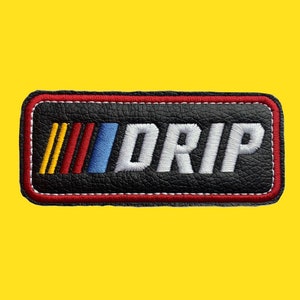 May include: Black leather patch with red stitching. The patch features a white "DRIP" text with a colorful racing stripe design.