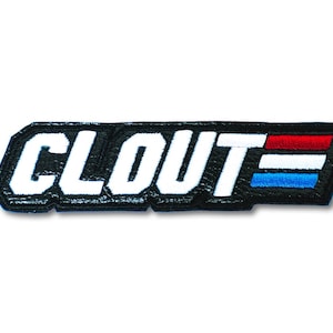 May include: Black and white embroidered patch with the word "CLOUT" in white letters with a red, white, and blue stripe design.