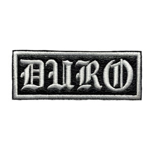 May include: Embroidered patch with the word "ILRO" in white gothic lettering on a black background. The patch has a black border and a white stitched edge. The patch is rectangular.