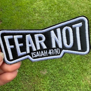 May include: White embroidered patch with black background. The patch says "FEAR NOT" with "ISAIAH 41:10" underneath.