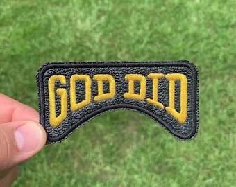 May include: Black leather patch with yellow embroidered text that reads "GOD DID".