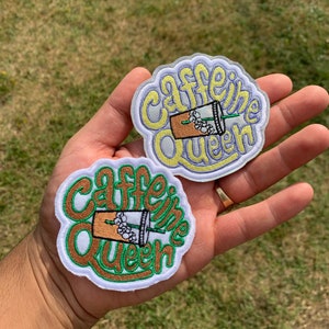 May include: Two embroidered patches with the text "Caffeine Queen" in a white, green, and brown color scheme. Each patch features a cartoon image of a coffee cup with a straw and ice cubes.