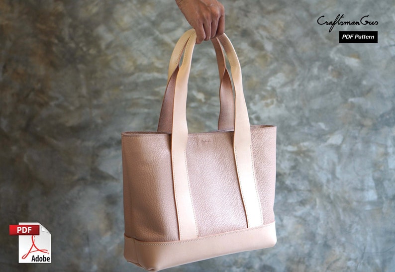 May include: A blush-colored leather tote bag with light beige straps and accents. The bag has a rectangular shape with a textured surface and a solid base. The Craftsman Gus PDF Pattern logo is visible in the upper right corner.