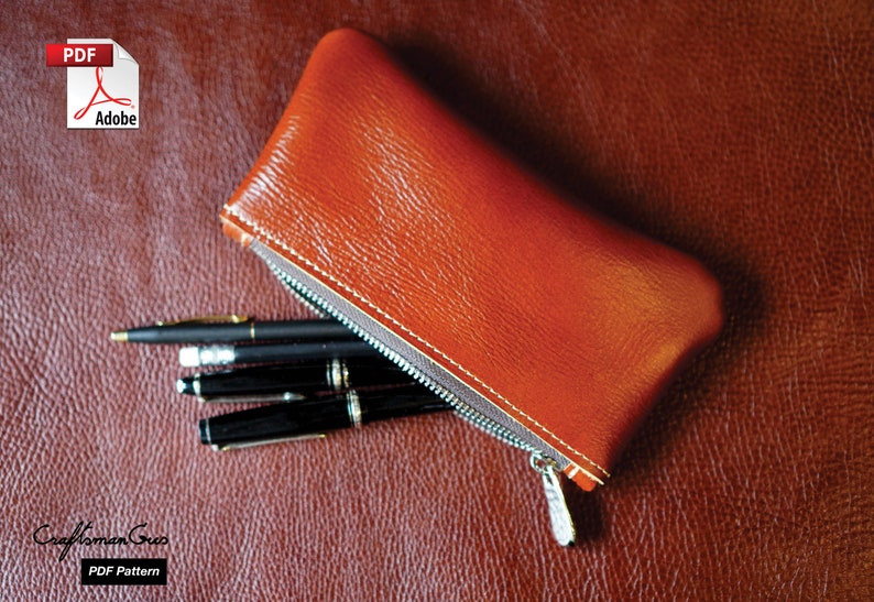 K&ouml;nnte beinhalten: Eine braune Leder-Rei&szlig;verschlusstasche mit einem Rei&szlig;verschluss-Zipper und vier schwarzen Stiften im Inneren. Die Tasche liegt auf einer braunen, strukturierten Oberfl&auml;che. Der Text "PDF Pattern" ist in der linken unteren Ecke des Bildes sichtbar.