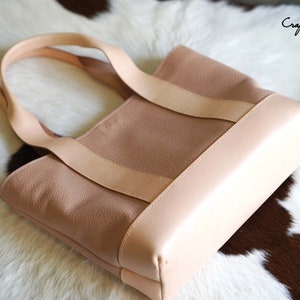May include: A light pink tote bag with a light tan trim and straps. The bag is made of a textured material and has a rectangular shape. The text "Craftsman Gus PDF Pattern" is visible in the upper right corner.