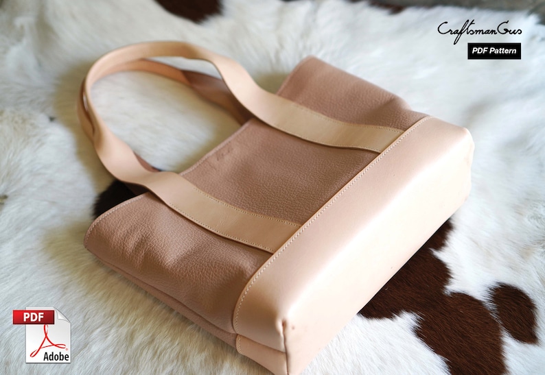 May include: A light pink tote bag with a light tan trim and straps. The bag is made of a textured material and has a rectangular shape. The text "Craftsman Gus PDF Pattern" is visible in the upper right corner.