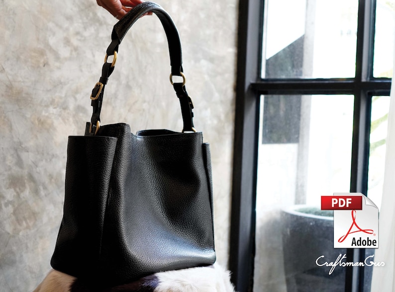 May include: A black leather tote bag with gold hardware and a structured shape.