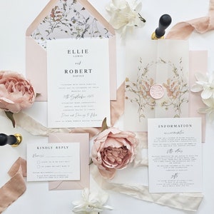 Op de afbeelding: Een huwelijksuitnodigingsset met een bloemenontwerp. De uitnodiging is gedrukt op wit karton met een roze envelop. De RSVP-kaart is gedrukt op wit karton met een roze envelop. De informatiekaart is gedrukt op wit karton met een roze envelop. De tekst op de uitnodiging luidt "Ellie Lewis en Robert Davies, 15 september 2025, De ceremonie begint om 13:00 uur, Dansen en dansen daarna".
