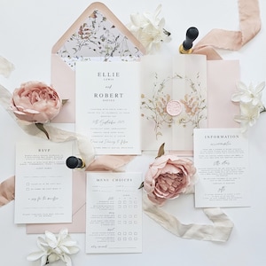 Op de afbeelding: Huwelijksuitnodigingsset met een bloemenontwerp. De uitnodiging bevat de namen Ellie Lewis en Robert Davies, de datum van de bruiloft en de locatie. De RSVP-kaart bevat een menukeuzegedeelte met opties voor gasten om hun maaltijdvoorkeuren te selecteren. De informatiekaart geeft details over de bruiloft.