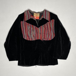 May include: A black velvet jacket with a striped collar and a colorful patterned panel across the chest. The jacket has a zipper closure and long sleeves. The label on the jacket reads "Jonet's".