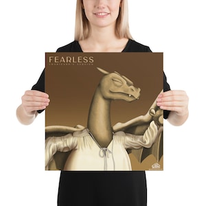 May include: A brown and beige illustration of a dragon wearing a white shirt with a brown background. The text "FEARLESS" and "CHARIZARD'S VERSION" is at the top of the image.