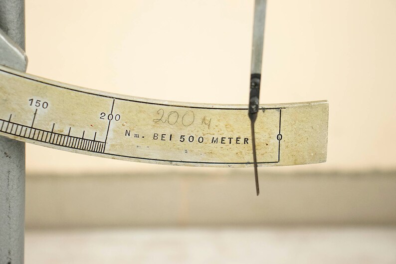 May include: A white measuring device with a black needle and a scale marked in meters. The needle is pointing to 200 meters. The device is labeled "N.m. BEI 500 METER".