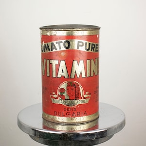 May include: Red and white metal can with the words "Tomato Pure Vitamin" and "Bulgarplodexport Sofia Bulgaria".