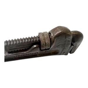 May include: A vintage, rusty, adjustable pipe wrench with a black finish and the text "THE WM.T. TOOL CO.".