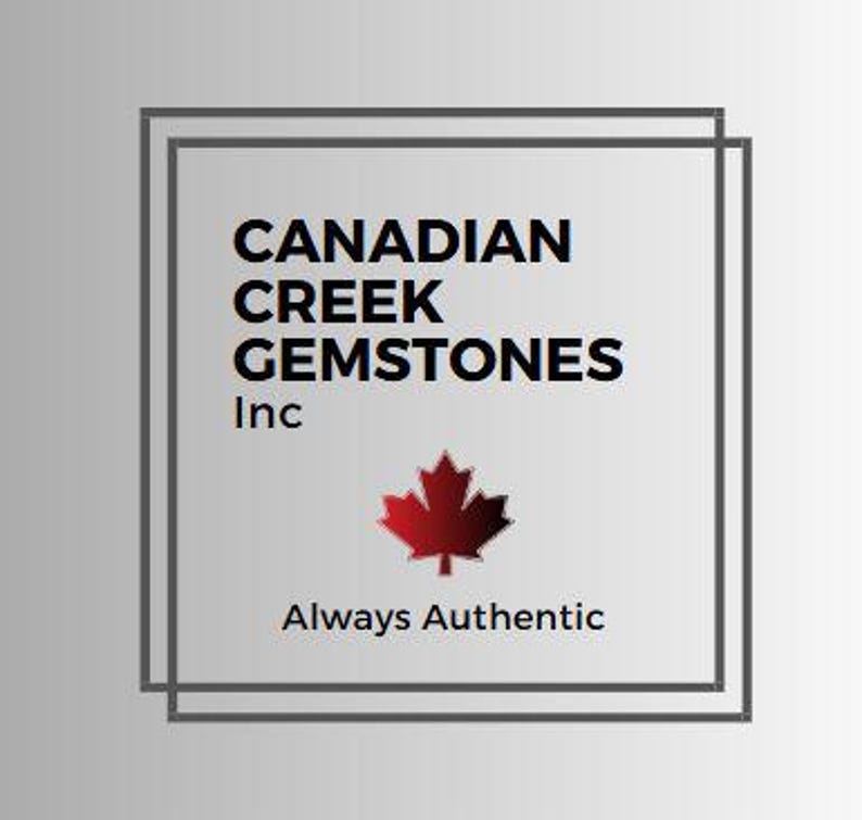 May include: Logo for Canadian Creek Gemstones Inc. The logo features a red maple leaf and the text "CANADIAN CREEK GEMSTONES Inc" above the text "Always Authentic" in a square frame.