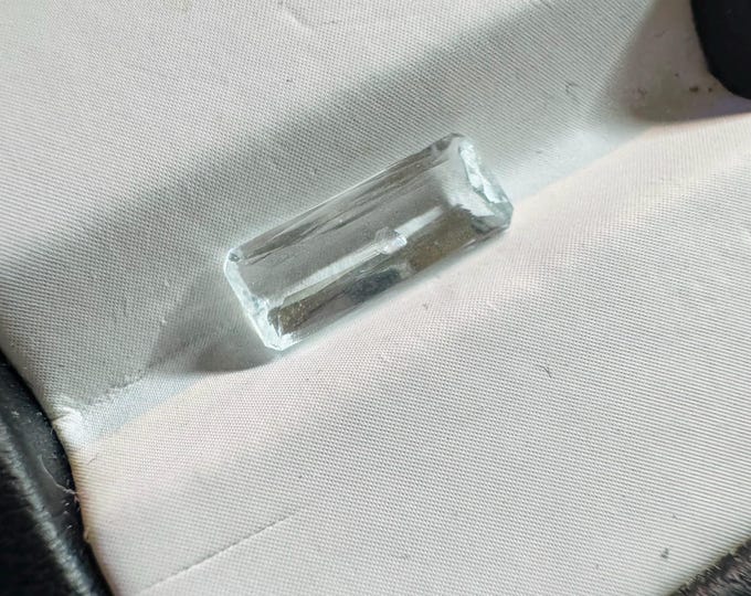 Discounted: 1.25 Carat Natural Aquamarine. Faceted Rectangle Cut Loose Gemstone for Making Pendants. Table Damage. 11.7 x 4.5 x 2.9 mm.