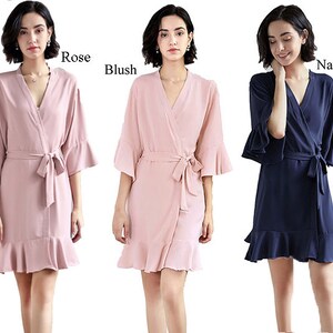May include: Three women's robes in pink, blush, and navy blue with ruffled trim and a tie belt. The robes are made of a soft, silky fabric and are perfect for getting ready for a special occasion.