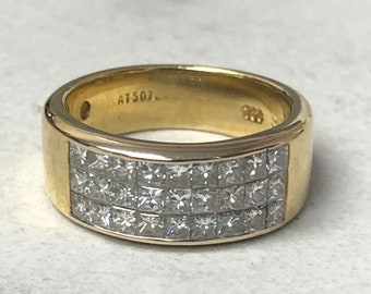 Op de afbeelding: Een gouden ring met een rij vierkante diamanten die in de band zijn gezet. De ring is gemarkeerd met "AT507".