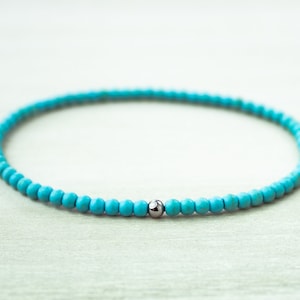 May include: A turquoise beaded bracelet with a silver bead accent.