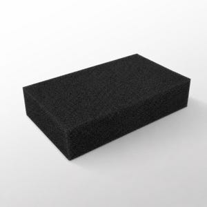 Op de afbeelding: Een rechthoekig zwart schuimblok. Het blok heeft een poreuze textuur en is gelijkmatig gekleurd. Het object is effen matzwart en staat tegen een witte achtergrond.