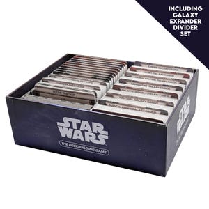Pode incluir: Um conjunto de cartas pretas do jogo de construção de baralhos Star Wars. A caixa inclui um Galaxy Expander Divider Set. As cartas são organizadas com divisórias rotuladas como "Empire Galaxy Cards", "Neutral Galaxy Cards", etc. O logotipo Star Wars é visível.