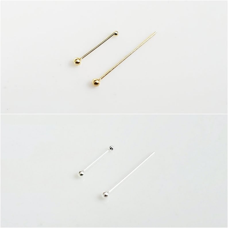 May include: Two pairs of head pins, one pair is gold and the other is silver. The pins are different lengths.