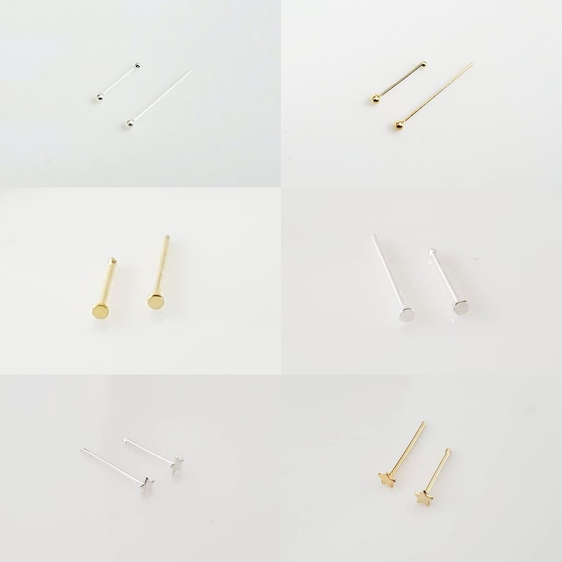 May include: A set of six nose rings in silver and gold. The rings have different styles, including a ball, a flat disc, and a star.